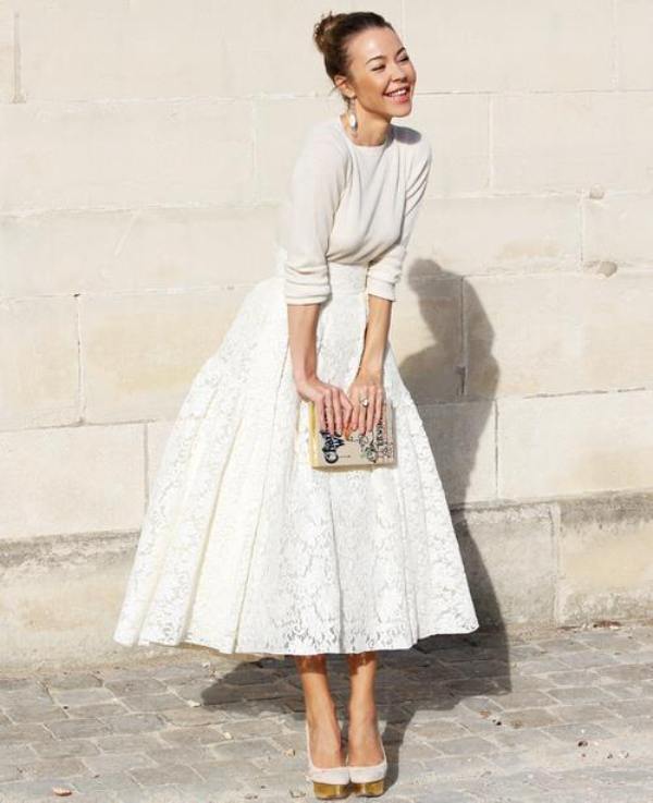 A neutral long sleeve top, a white a line lace midi skirt, white shoes and a whimsical clutch for a casual fall or winter bridal look