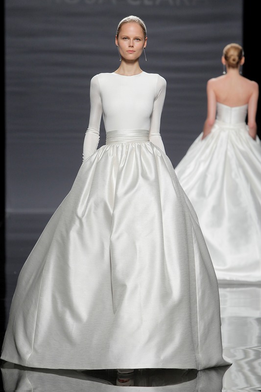 A white fitting long sleeve top with a high neckline and a shiny full skirt with a sash for a more formal look at the wedding