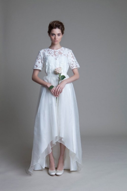 a white lace top with a high neckline and short sleeves, a layered high low skirt with a train for a romantic and chic look