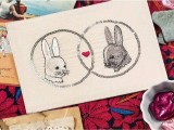 a neutral wedding invitation with embroidered bunnies and a heart in the center is a lovely idea for a cozy wedding