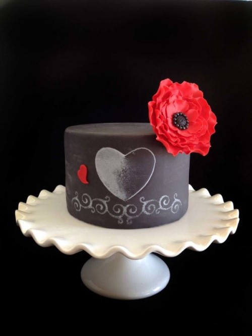 a black chalkboard wedding cake with chalking and a red bloom on top is a lovely idea for a modern wedding, a bright and contrasting one