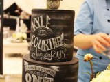 a chalkboard wedding cake with some chalking to perfectly style it for a relaxed, rustic or some other wedding