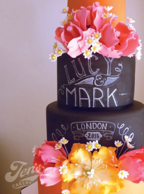 a chalkboard wedding cake with orange tiers, with chalk detailing and bold blooms is a gorgeous idea for a modern wedding