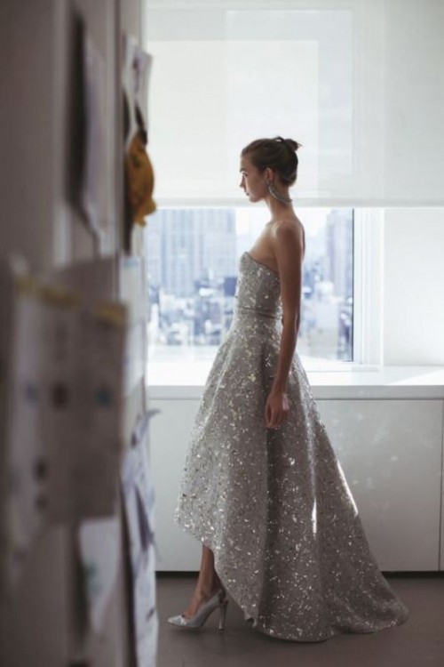 a strapless grey fully embellished A-line wedding dress with a high low skirt and silver shoes for a bold glam bridal look