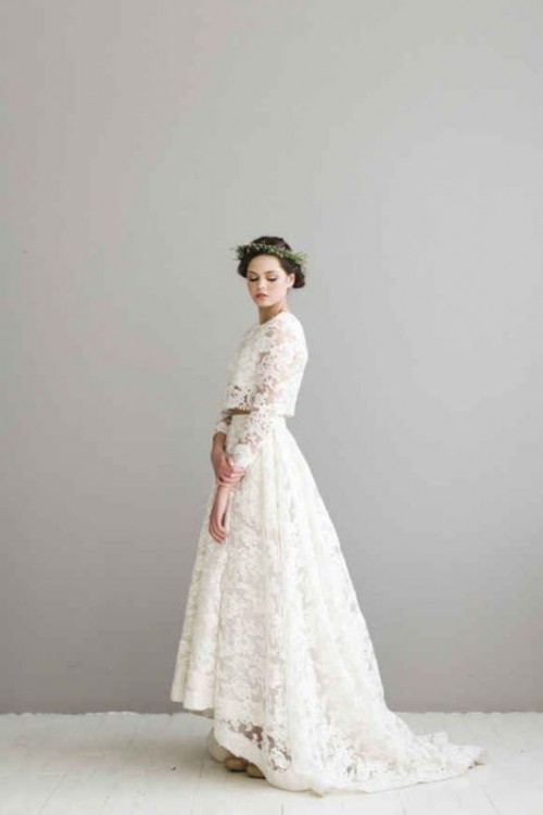 a romantic lace two-piece wedding dress with a crop top with long sleeves and a high low skirt with a train is a chic idea