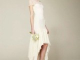a neutral high low wedding dress with an illusion strapless neckline and short sleeves, a high low ruffle skirt and white shoes