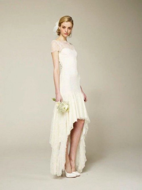 a neutral high low wedding dress with an illusion strapless neckline and short sleeves, a high low ruffle skirt and white shoes