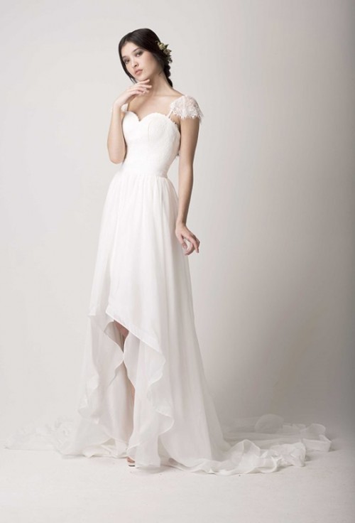 a romantic lace and ruffle high low wedding dress with a sweetheart neckline, lace cap sleeves and a skirt with a train