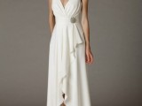a simple and cute plain A-line high low wedding dress with a draped bodice, a deep V-neckline, a vintage brooch and a skirt with ruffles and embellished shoes