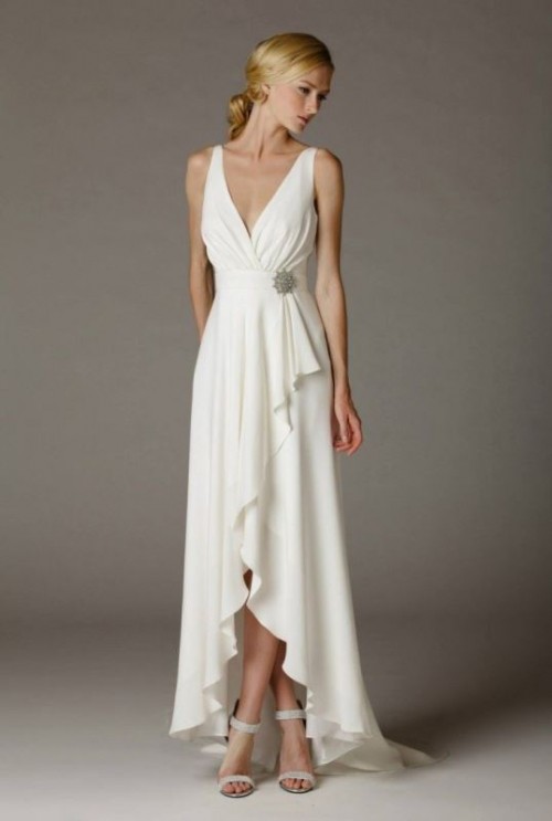 a simple and cute plain A-line high low wedding dress with a draped bodice, a deep V-neckline, a vintage brooch and a skirt with ruffles and embellished shoes