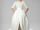 a dramatic wedding dress with an embellished bodice, a high neckline, short sleeves and a plain full skirt with a train and a front slit is bold