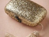 a gold glitter clutch with a tassel is a lovely shiny accessory for a bride, it will add a chic and bold touch to the look