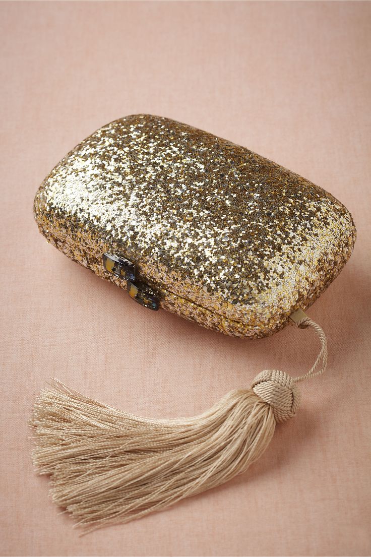 A gold glitter clutch with a tassel is a lovely shiny accessory for a bride, it will add a chic and bold touch to the look