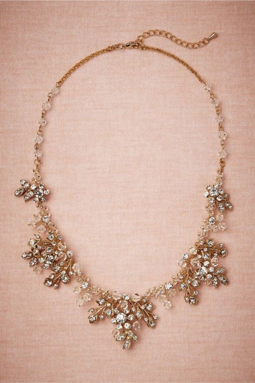a gold floral necklace showing intricate work, with leaves and crystals of white and yellow shade is a very sophisticated accessory for a bride