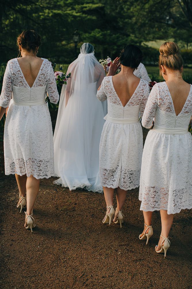 Classy white lace midi bridesmaid dresses with V cutout backs and nude shoes are amazing for a vintage neutral wedding