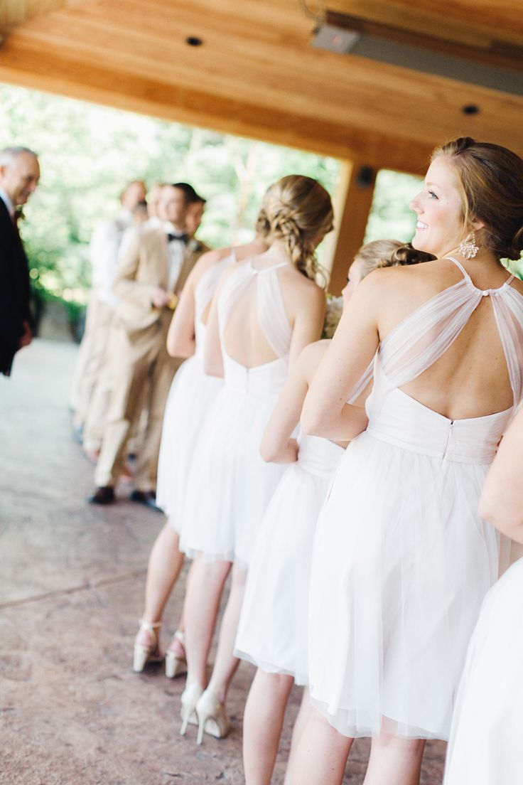Matching white over the knee A line bridesmaid dresses with cutout backs are gerat for a casual modern wedding