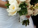 a delicate wedding bouquet of white tulips, neutral roses and succulents plus some privet berries is a chic and lovely idea for a bride