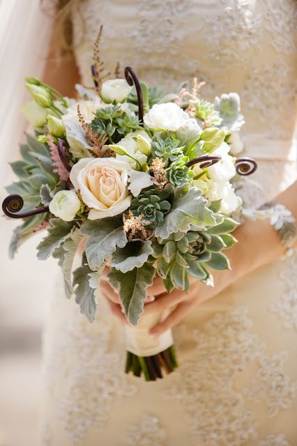 a neutral wedding bouquet of pink and white roses, succulents and pale greenery and some dark touches to give it a more eye-catchy look
