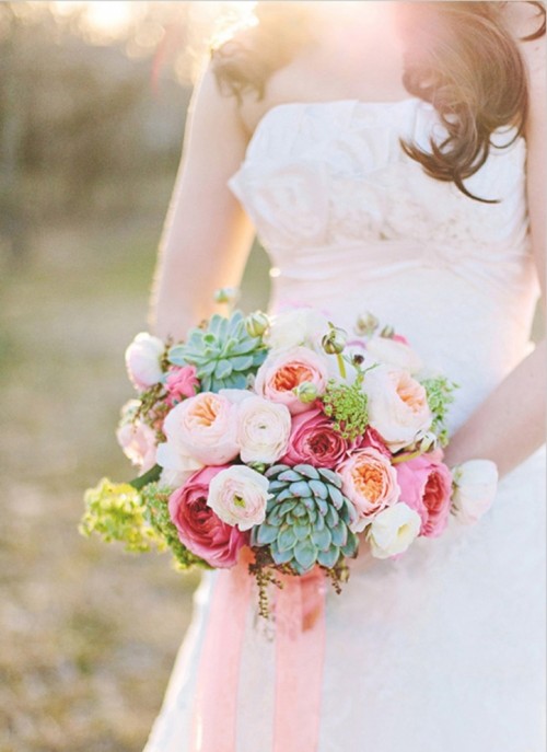 a bright summer wedding bouquet of blush ranunculus and peony roses, hot pink roses and greenery and succulents is a catchy and lively idea