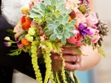 a colorful wedding bouquet with orange, blush and hot pink blooms, succulents of various shades with some cascading touches