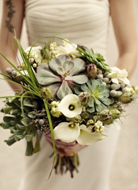a white wedding bouquet with callas, various types of succulents and berries and some grasses looks very unusual and bold