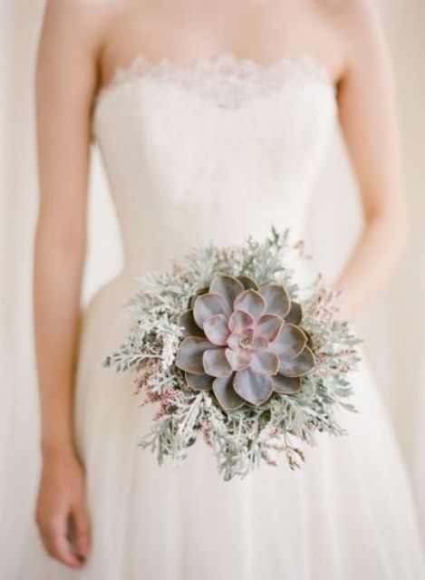 a small wedding bouquet of a large succulent surrounded with pale greenery is a stylish idea for a winter wedding