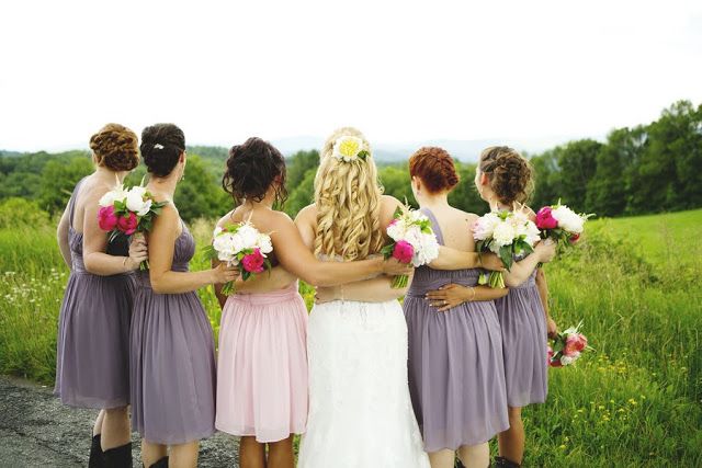 Mismatching short grey bridesmaid dresses and a light pink one for the maid of honor