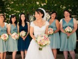 aqua midi dresses with fabric flowers for the bridesmaids and a teal gown for the maid of honor