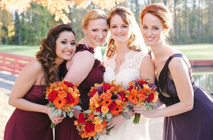 Mismatching burgundy dresses for the bridesmaids and a purple gown for the maid of honor