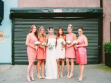 mismatching coral pink over the knee bridesmaid dresses and a strapless draped ivory one for the maid of honor