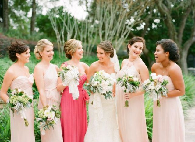 Mismatching blush bridesmaid dresses and a one shoulder coral pink maxi gown for the maid of honor