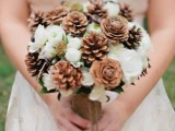 a pretty and cozy winter wedding bouquets of white blooms and pinecones is a cool idea for a rustic winter wedding