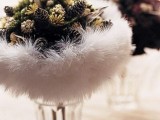 a unique winter wedding bouquet composed of usual and bleached pinecones, greenery and faux fur is a gorgeous idea for a rustic wedding