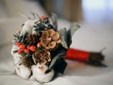a small Christmassy winter wedding bouquet of pinecones, cotton, berries and silver pinecones plus a red wrap is amazing for holidays