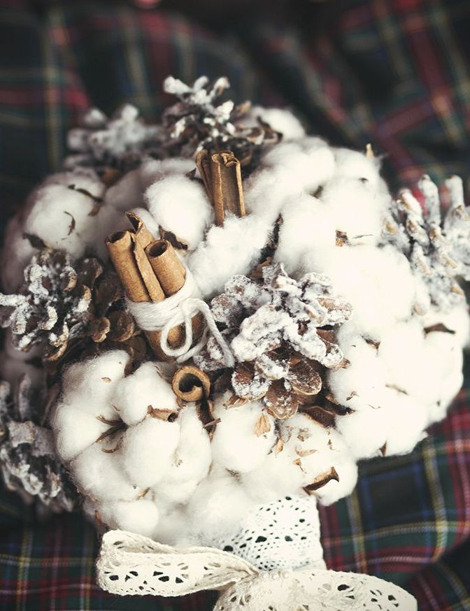 A cozy rustic winter wedding bouquet of cotton, snowy pinecones, cinnamon sticks plus a lace wrap is amazing