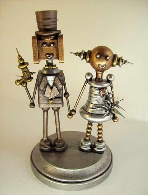 extremely creative metal cake toppers showing a steampunk bride and groom with some instruments is a very bold and cool idea to rock