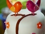 ccolorful bird cake toppers and colorful sugar blooms covering the cake make it cooler and funnier