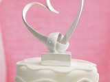 a beautiful white heart with a knot cake topper is a lovely idea for those who want a dreamy look and a refined touch to the cake