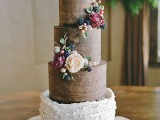 a gorgeous woodland wedding cake, partlychocolate and partly with white ruffles, with edible berries, greenery and branches