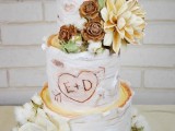 a rustic wedding cake with bark, sugar and real blooms, cotton, greenery