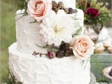 a chic textural buttercream wedding cake topped with fresh blooms and berries plus decorated with ferns