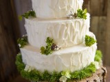 a cozy rustic woodland wedding cake with textural buttercream, moss, grass, berries and served on a wood slice