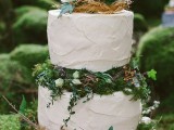 two white buttercream wedding cakes served with moss, succulents and greenery in between plus a faux nest on top