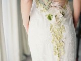 a chic lace sheath wedding dress with a sheer back with grene lace flower applique and leaves, a fabric flower and an embroidered birdie
