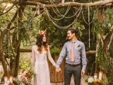 a boho lace sheath wedding dress with a sheer neckline, long sleeves and a bright floral crown