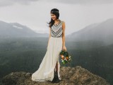 a folksy wedding dress with no sleeves and an A-line skirt with a slit plus blakc embroidery, black boots and a boho headpiece