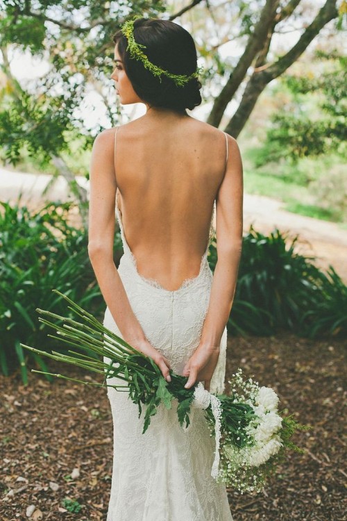 a sexy lace sheath wedding dress with spaghetti straps and an open back plus a greenery crown