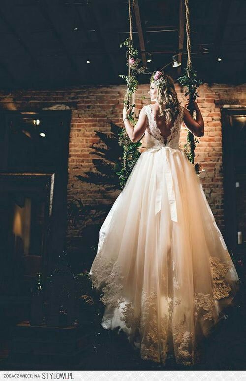 a chic and refined wedding dress with a lace bodice, an open back, a bow and a skirt with a train with lace