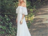 a boho off the shoulder wedding dress with a lace neckline and a train plus a floral crown