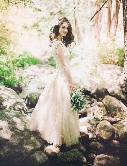 a neutral lace and tulle wedding dress with no sleeves and a high neckline plus an A-line skirt